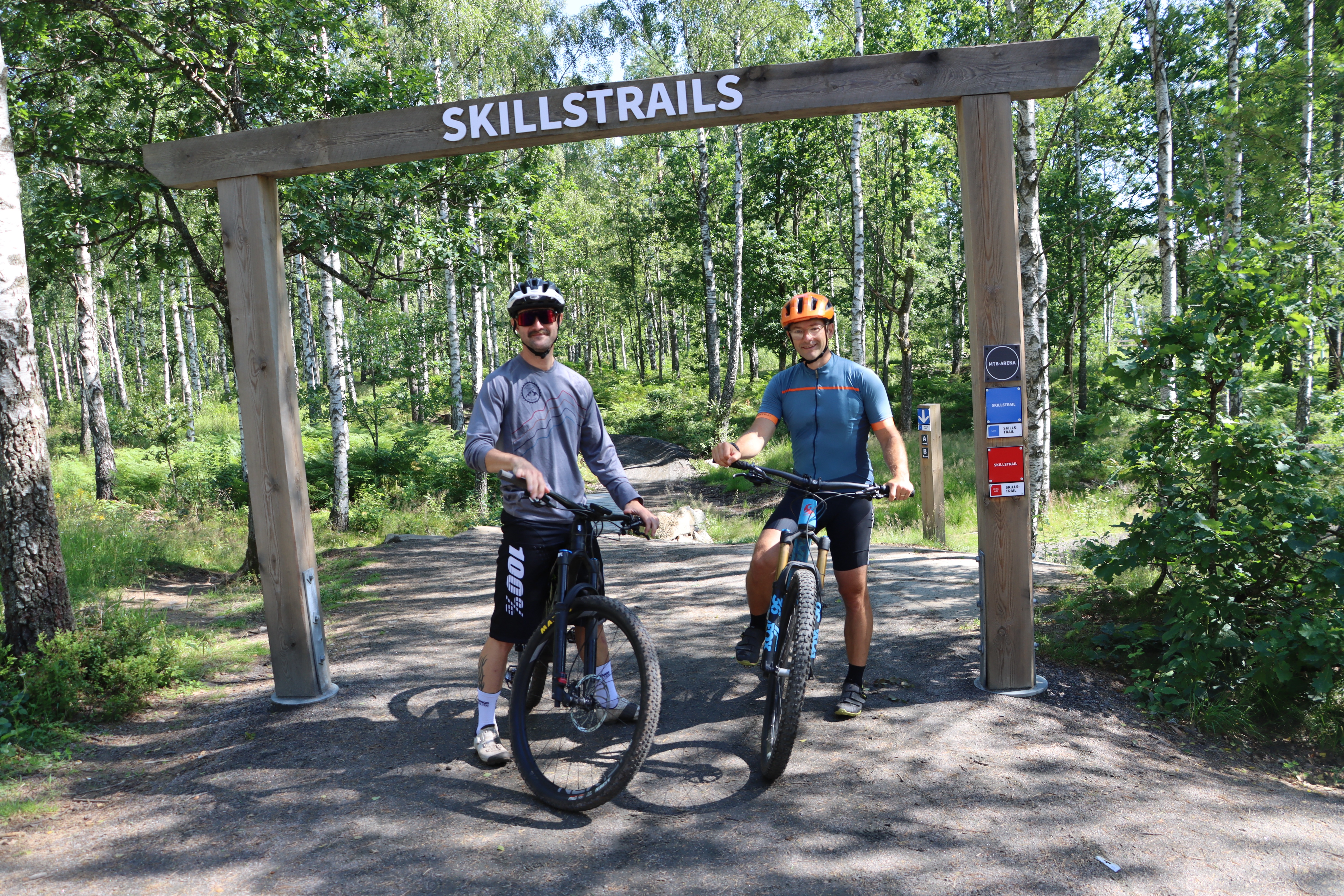 Två cyklister vid Skillstrails-skylten på Billingen